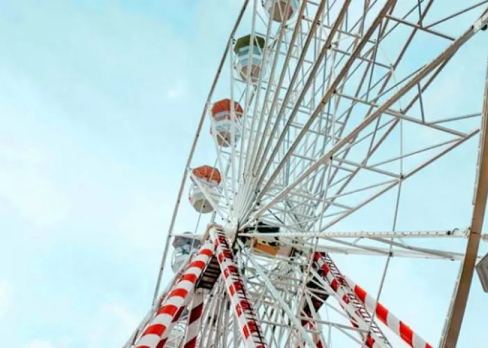 Close up ferris wheel, blue sky with clouds in background